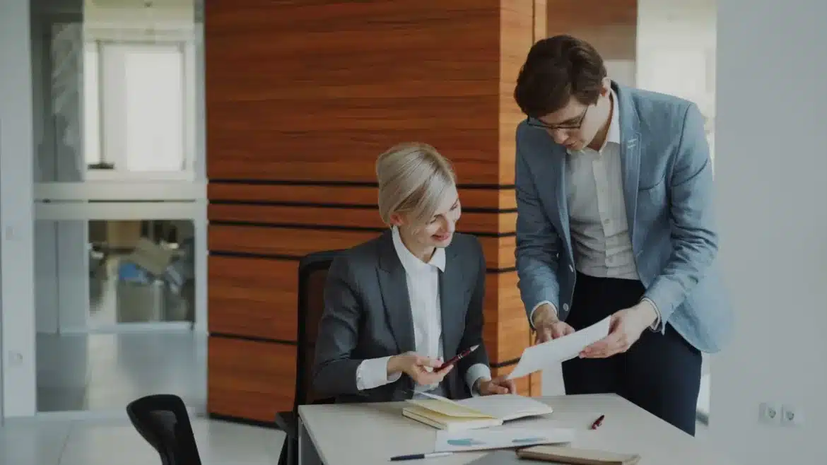 Personne travaillant sur un projet de reconversion professionnelle avec documents et ordinateur portable