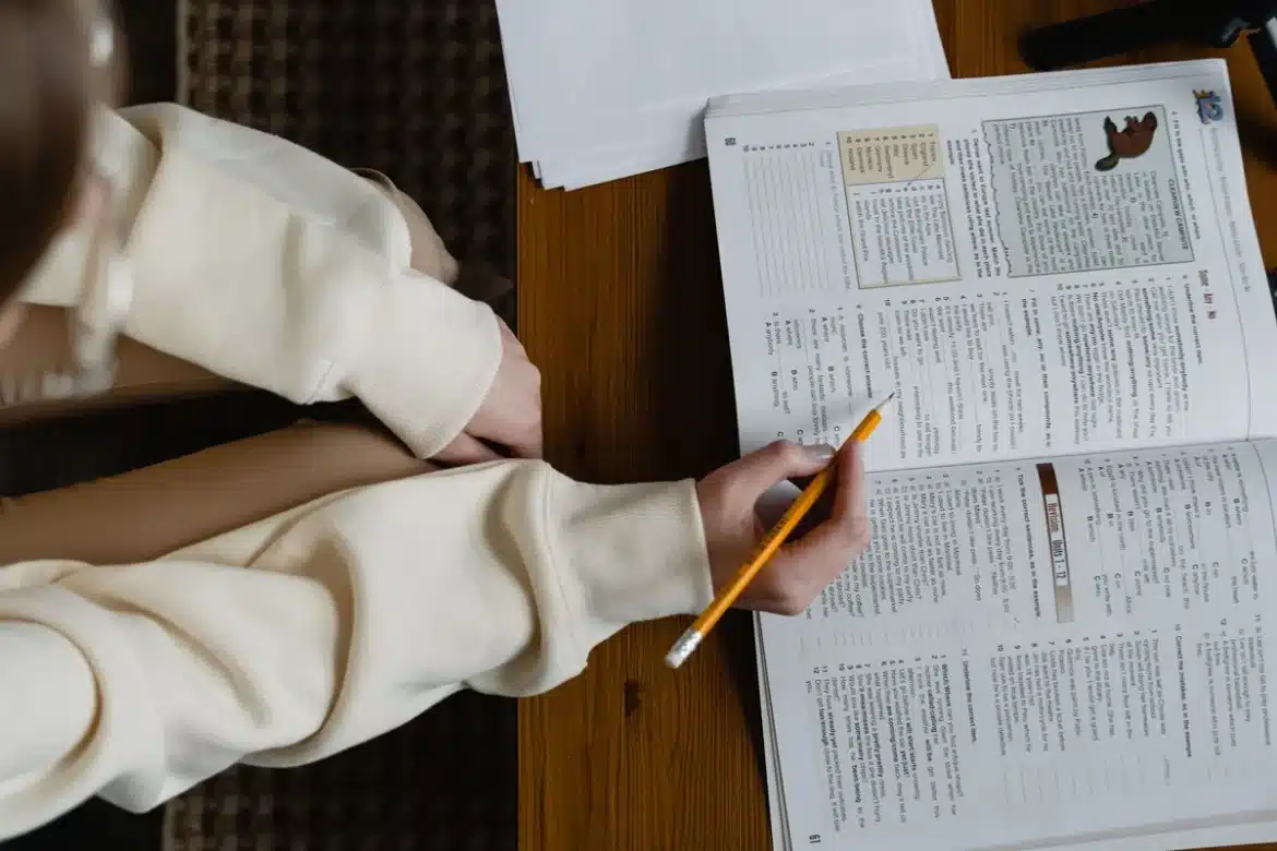 Étudiant révisant à un bureau avec des livres et des notes autour de lui