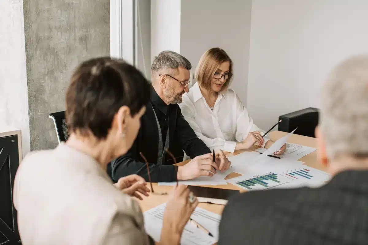 Groupe de personnes en réunion discutant autour d'une table de travail