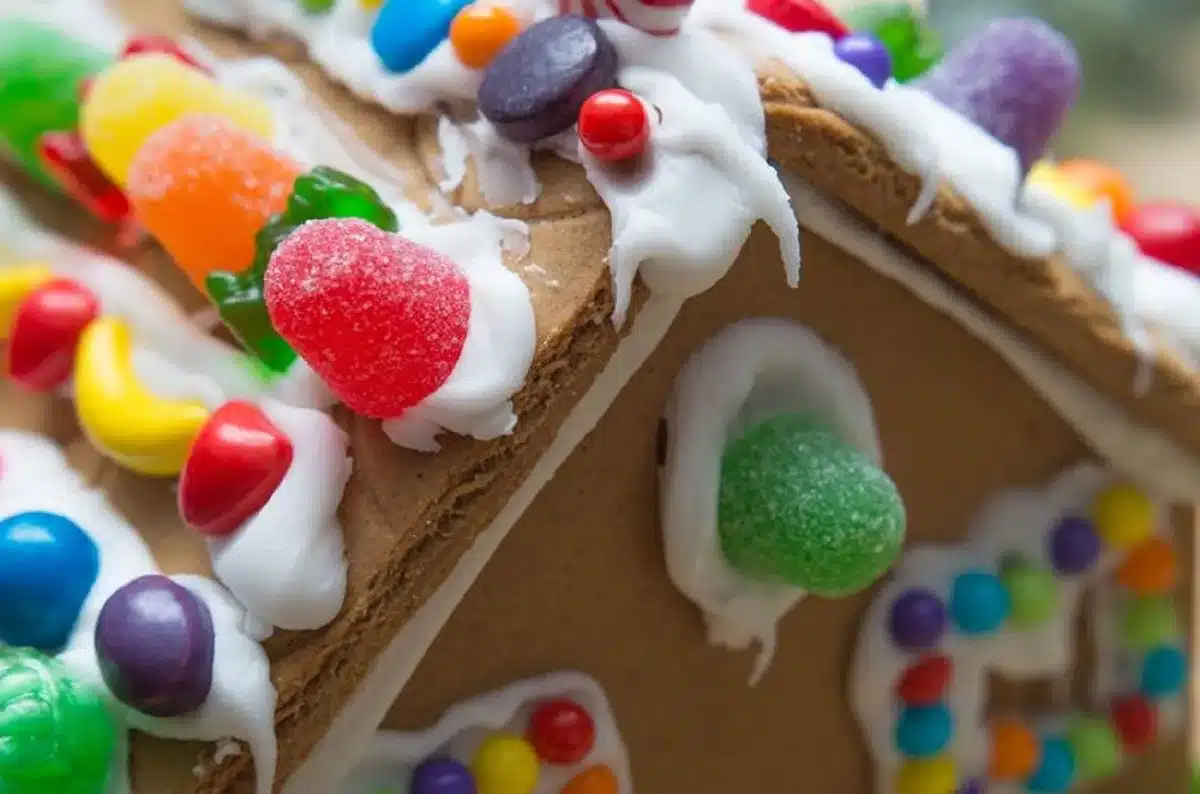 Groupe de personnes décorées une maison en pain d'épices lors d'une activité collective festive