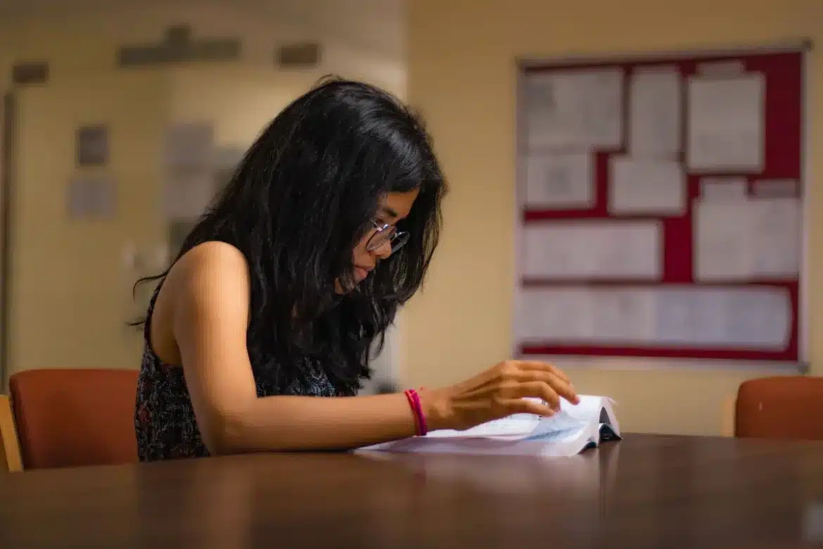 Adulte en train d'étudier à son bureau avec des livres et des notes, préparant ses examens