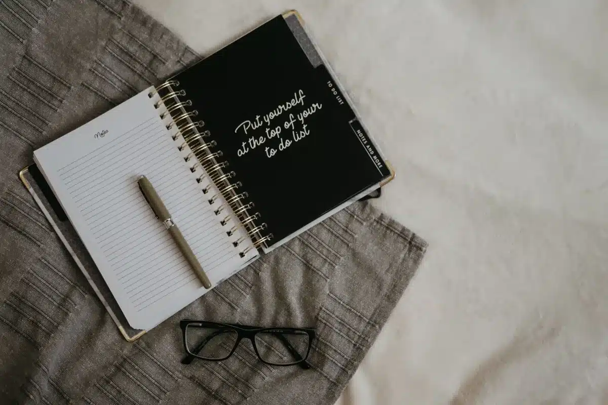Un carnet ouvert avec une liste de lecture et un stylo, organisé pour planifier des lectures mensuelles