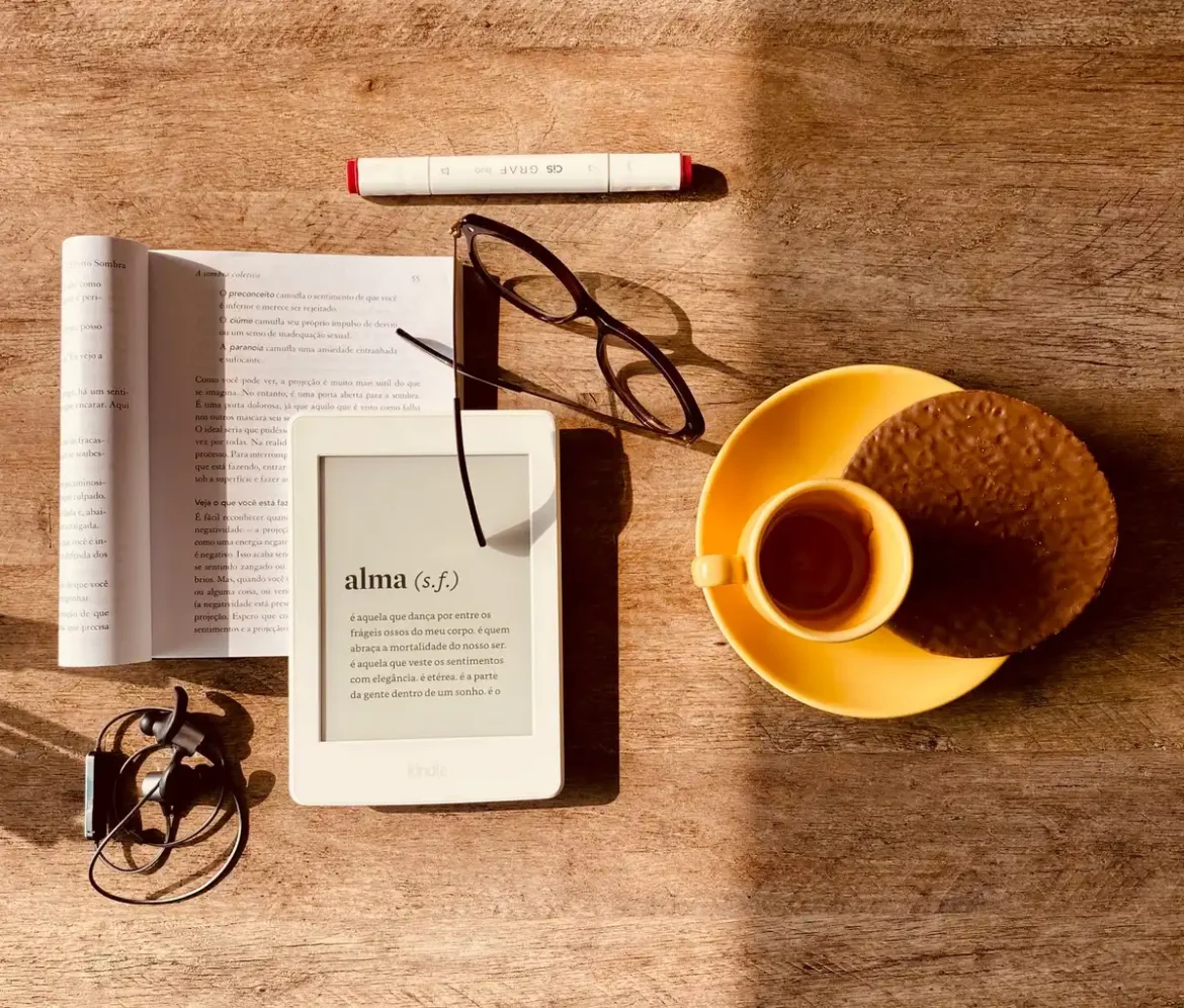 Un livre ouvert sur un bureau avec une tasse de café, lumière naturelle douce