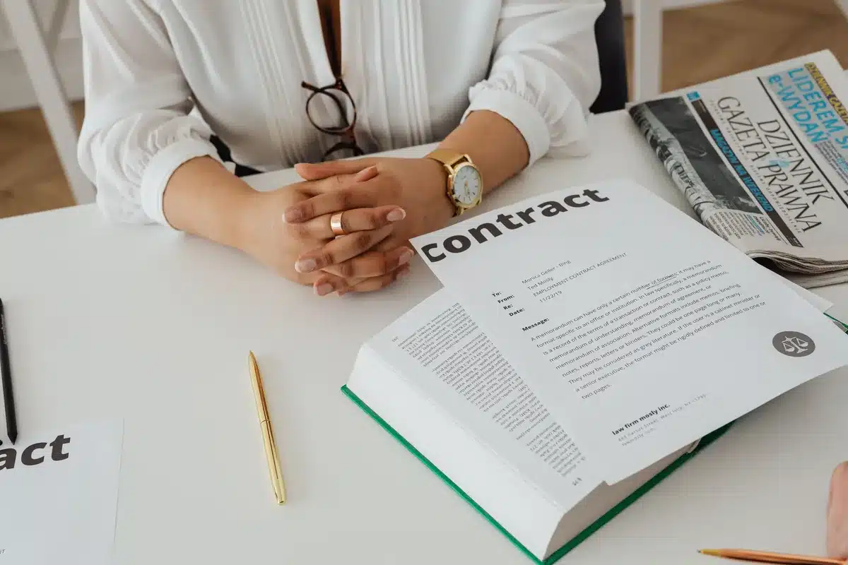 Une personne examine attentivement les clauses d'une convention de rupture avant de la signer