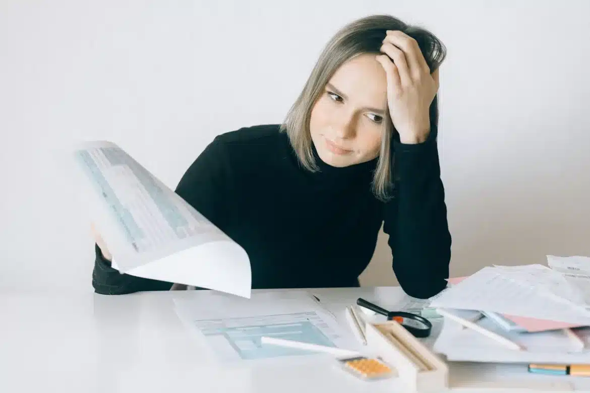 Femme enceinte assise à un bureau avec des documents légaux, illustrant la protection légale pendant la période d'essai