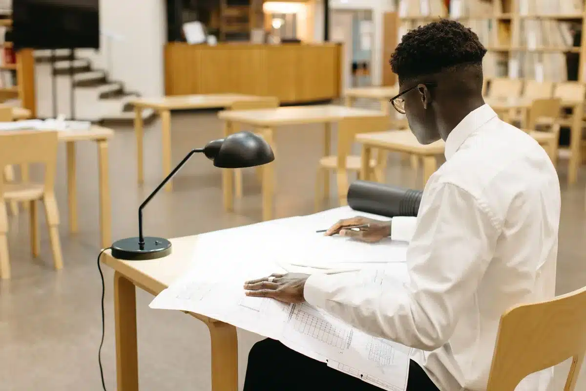 Étudiant en train de planifier son parcours professionnel avec des documents et un ordinateur portable