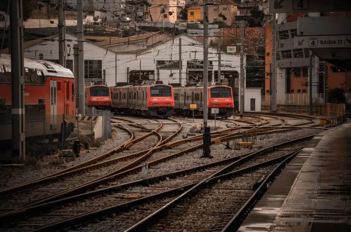 Équipes variées dans un dépôt ferroviaire moderne : technicien, analyste et agent d'accueil.
