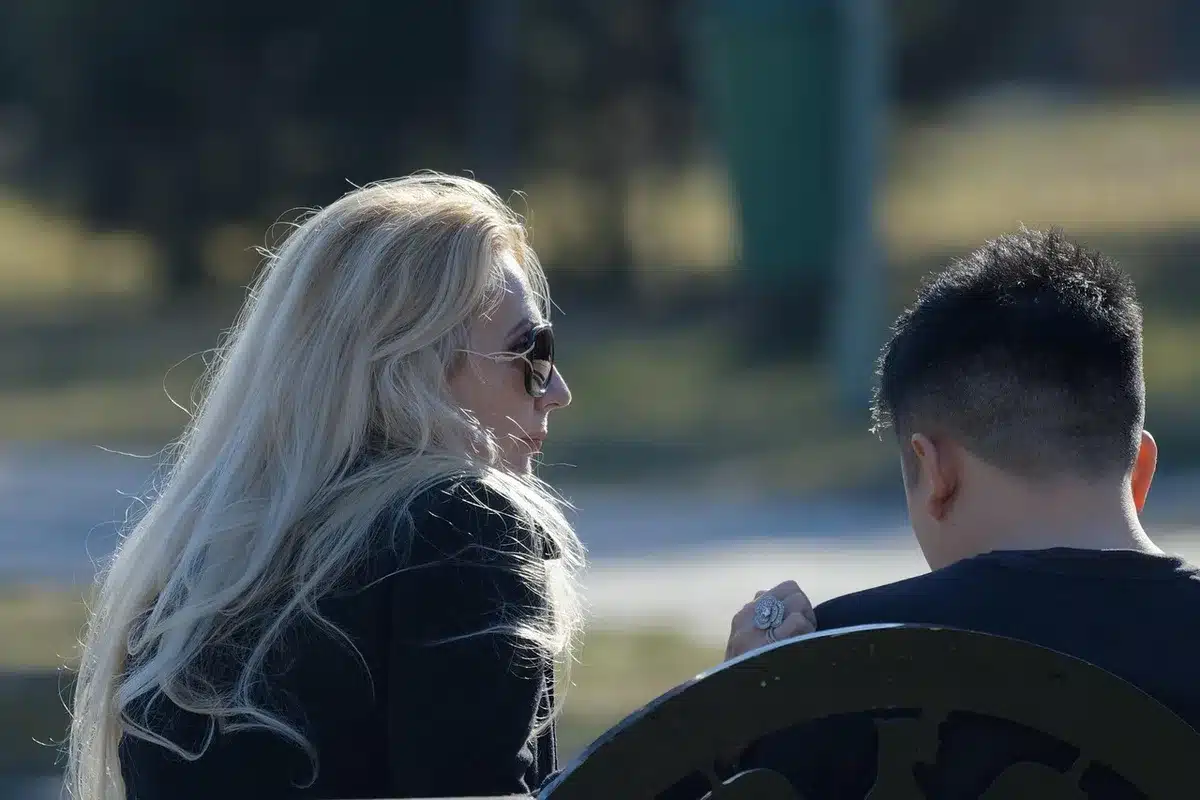 Couple mûr assis sur un banc de parc en journée discutant