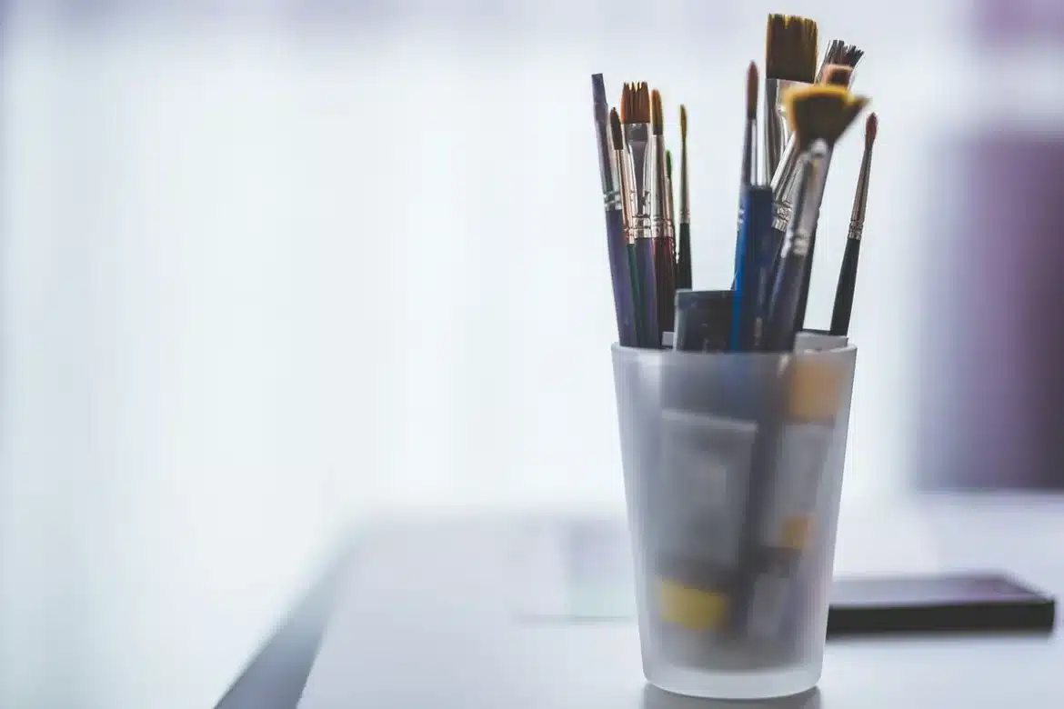 Espace de travail d'artiste avec matériel créatif, croquis et outils dispersés sur une table