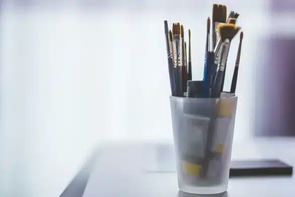 Espace de travail d'artiste avec matériel créatif, croquis et outils dispersés sur une table