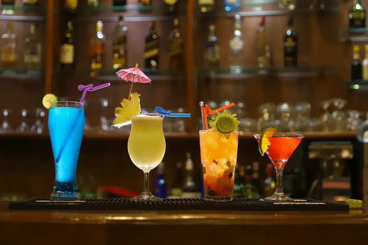 Événement professionnel avec bar à mocktails colorés et collègues en interaction conviviale.