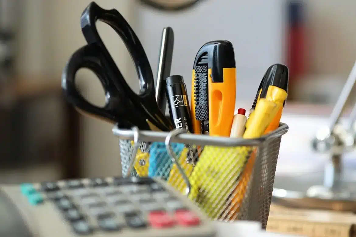 Mains tenant des reçus et une calculatrice sur une table ensoleillée