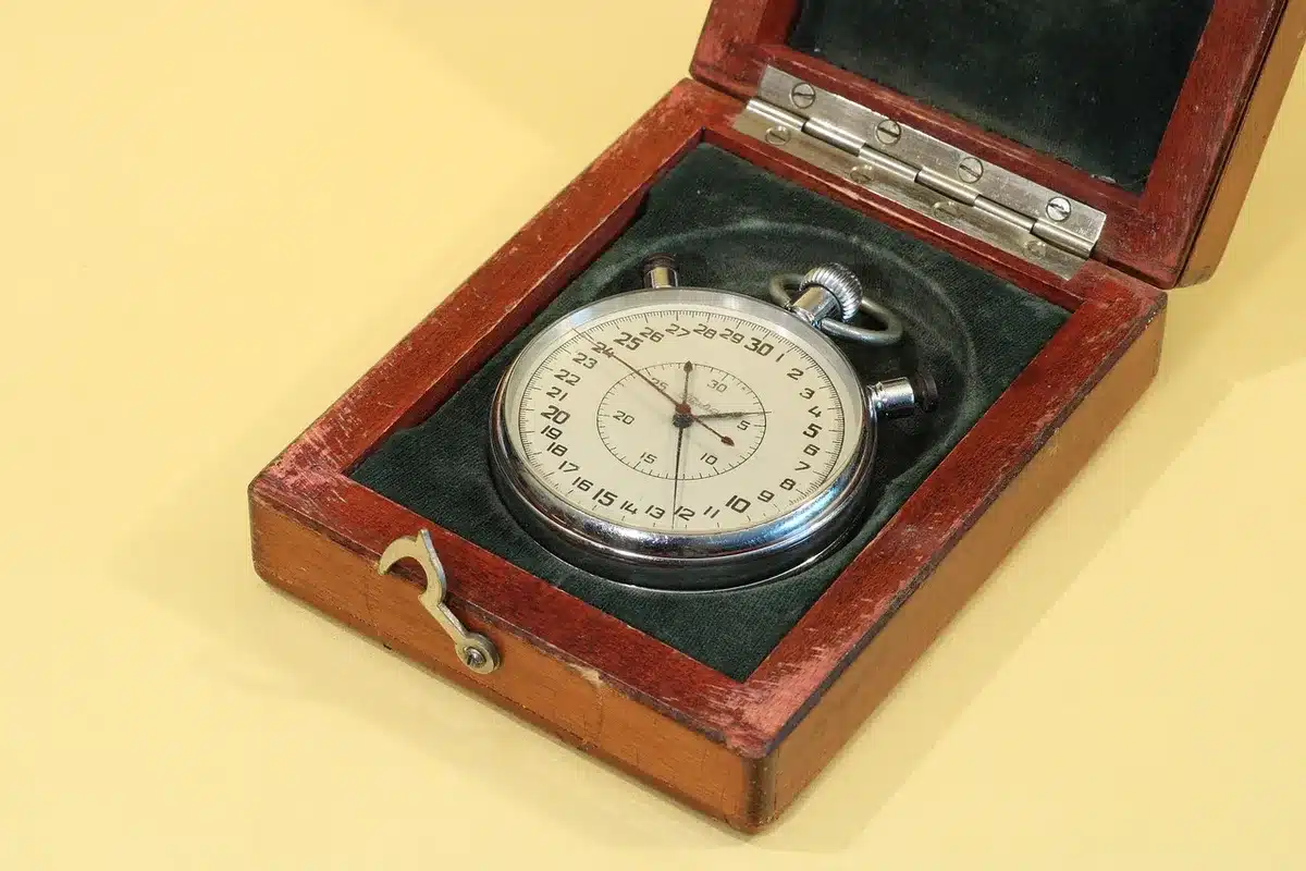 Chronomètre et feuille de temps de travail posés sur un bureau de révision