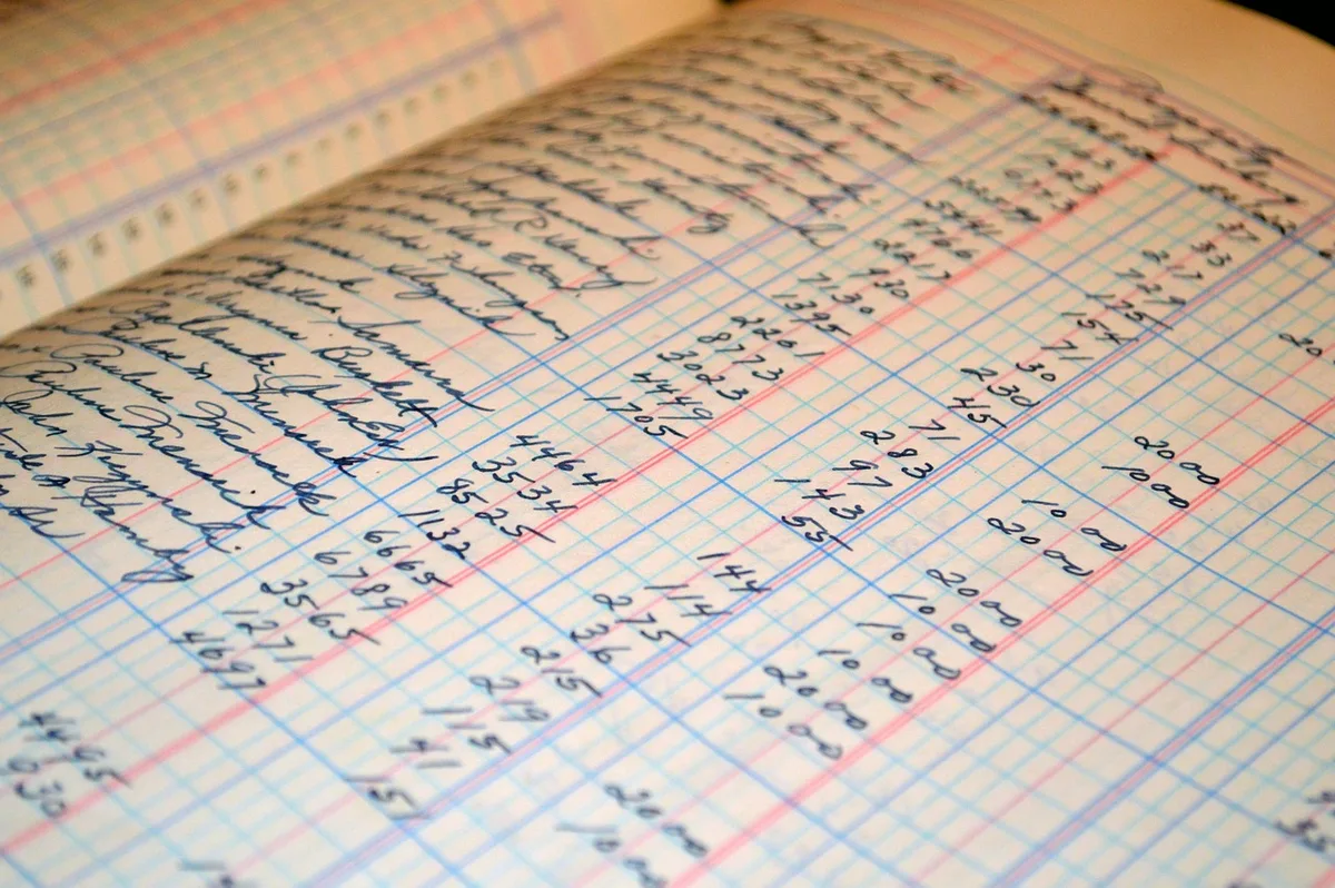 Formulaire de bénéficiaire posé sur un bureau avec mains en train de signer