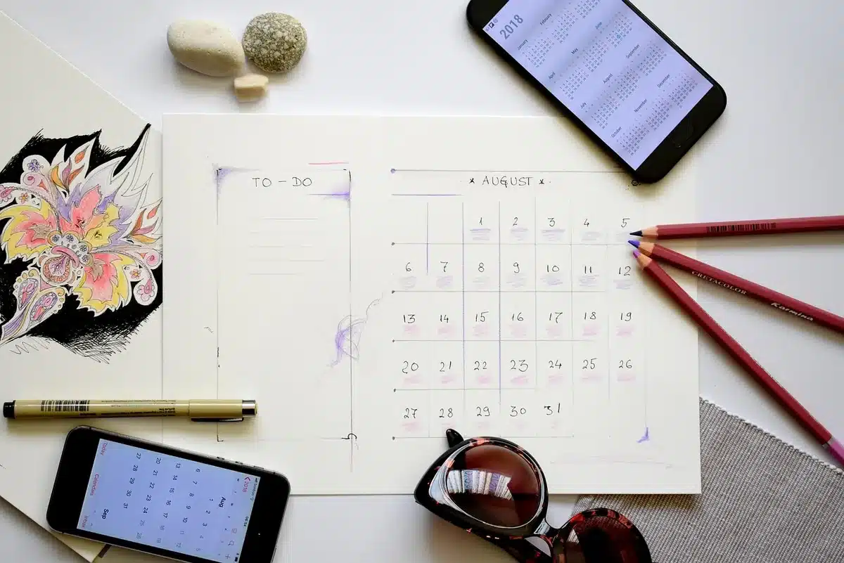 Planning hebdomadaire posé sur un bureau avec calendrier et stylos