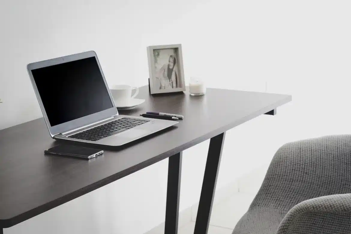 Personne travaillant sur plusieurs écrans dans un bureau à domicile bien aménagé