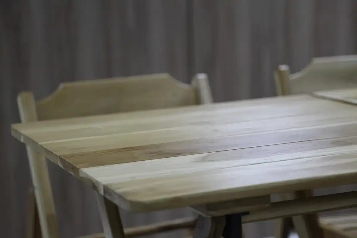 Casque audio posé à côté d'un livre sur une table, symbolisant audiolivre et papier