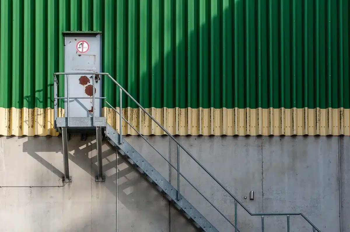 Entrepôt industriel avec employés et palettes, illustrant demande en logistique