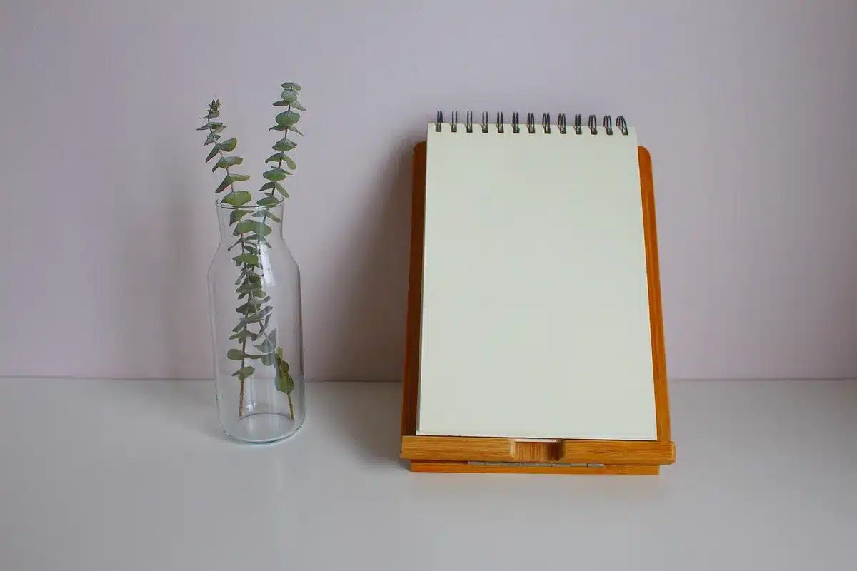 Couple annotant une checklist financière sur un carnet près d'une fenêtre