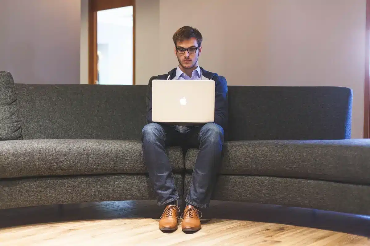 Personne en télétravail devant un grand fenêtre avec ordinateur portable