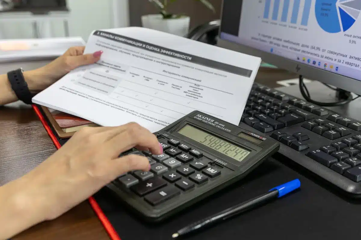 Calculatrice et documents de paie sur un bureau pour estimer la valeur des avantages