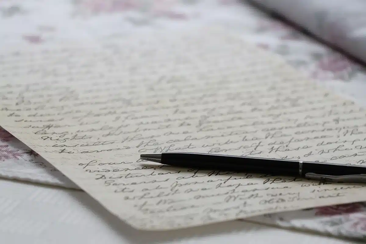 Des lettres manuscrites étalées sur un bureau éclairé par la fenêtre
