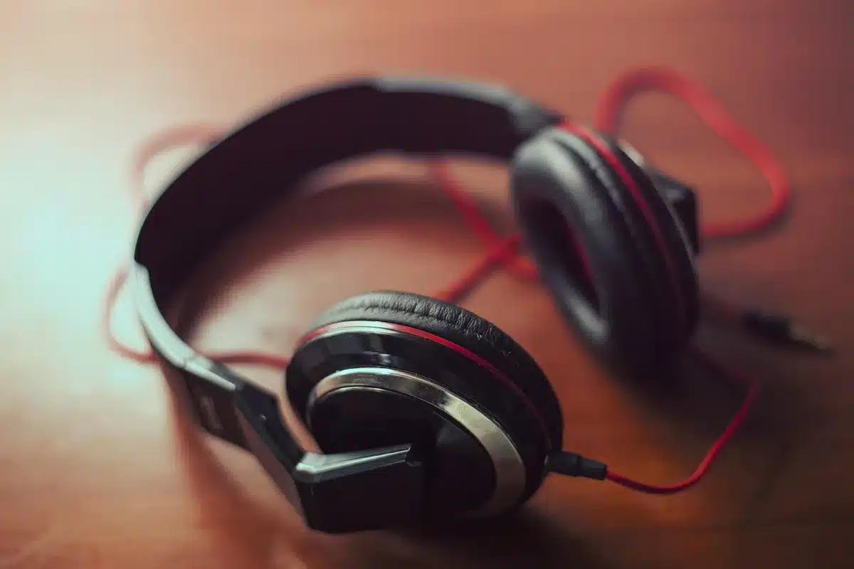 Écouteurs posés sur un carnet près d'une tasse, évoquant l'écoute d'un livre audio