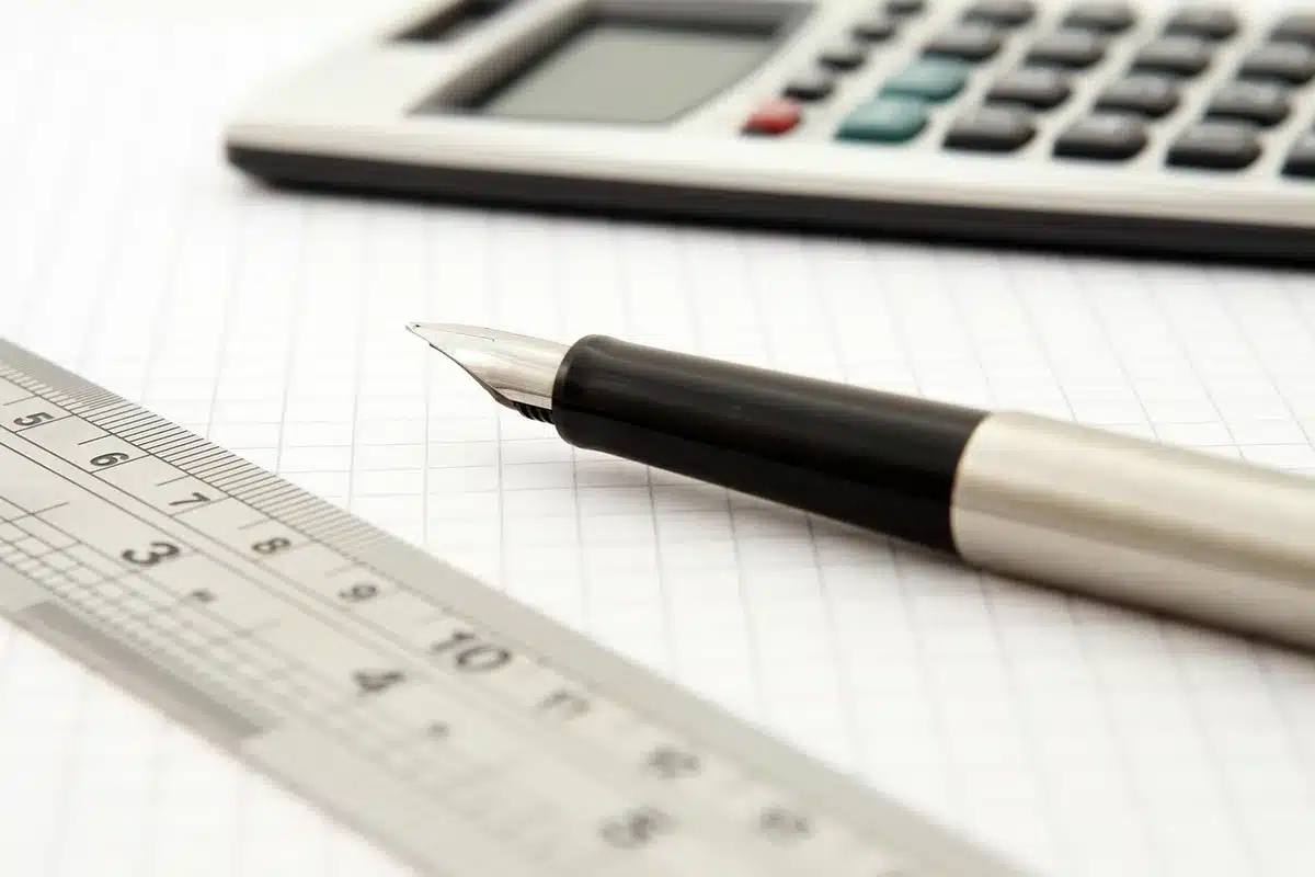 Calculatrice et quittance de loyer sur une table pour chiffrer frais et cashback