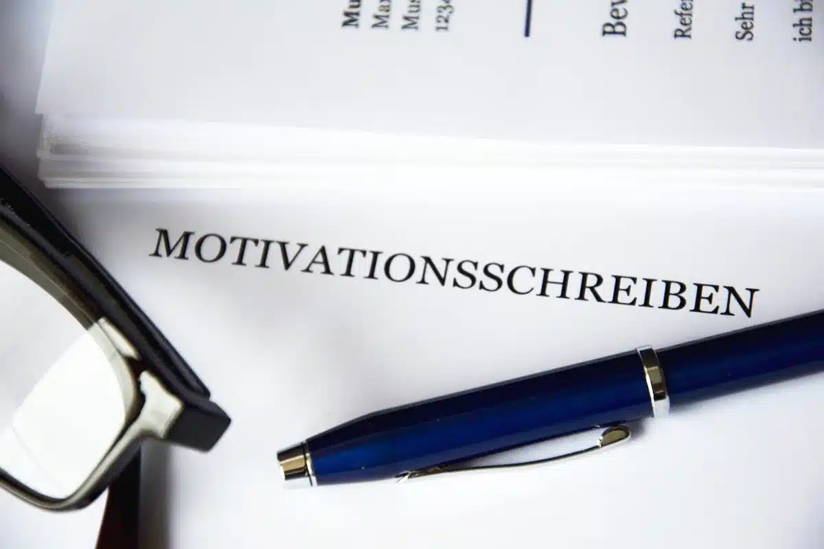 Pile de candidatures et un ordinateur montrant une offre d'emploi