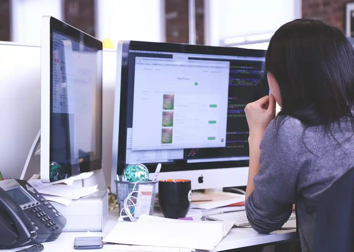 Ordinateur affichant un portfolio de projets et code, posé sur un bureau ensoleillé